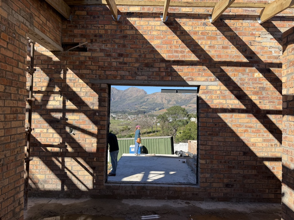 Johannesdal — sunlit brick interior under construction with mountain view