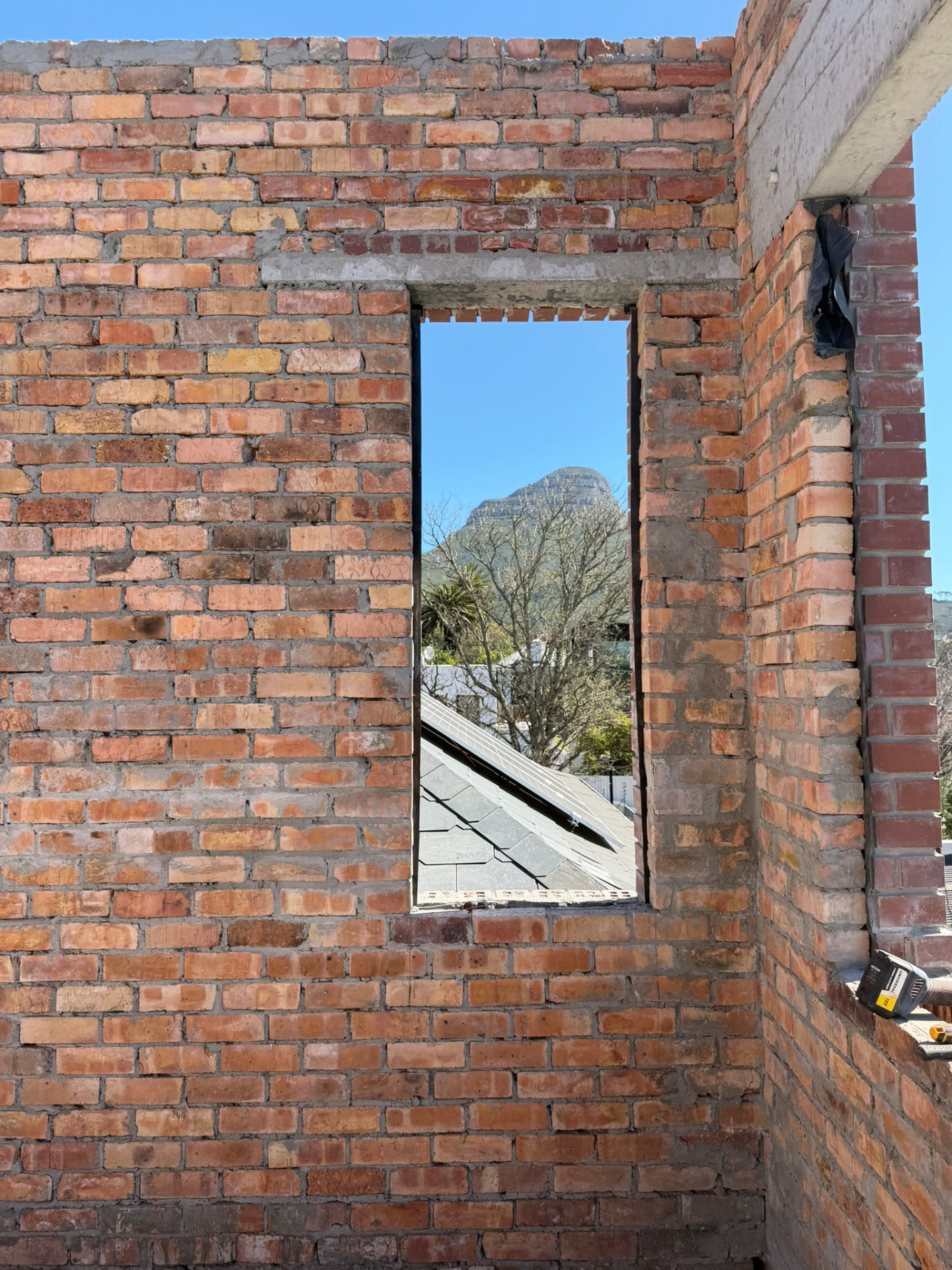 Forest — red-brick opening framing the mountain and city rooftops